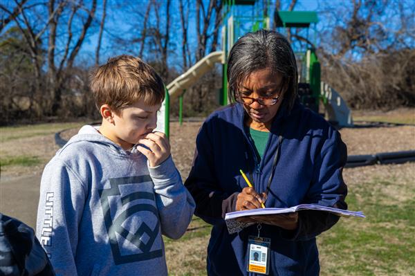 teacher and student writing in notebook